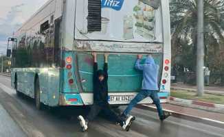 Halk otobüsü arkasına takılan patenli çocukların tehlikeli yolculuğu